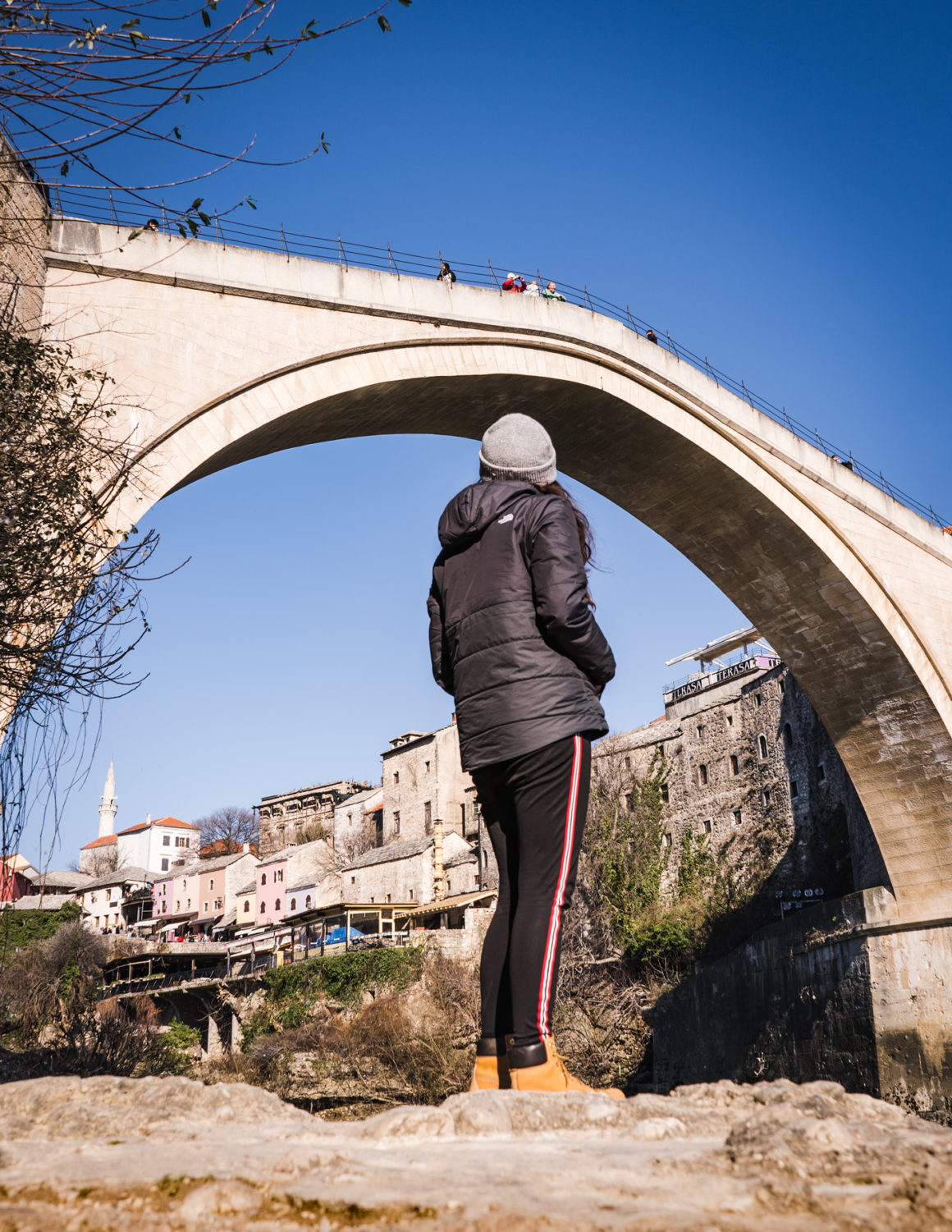 Katie looks up at a bridge in the Old Town of Moscar, Bosnia & Herzevegonia