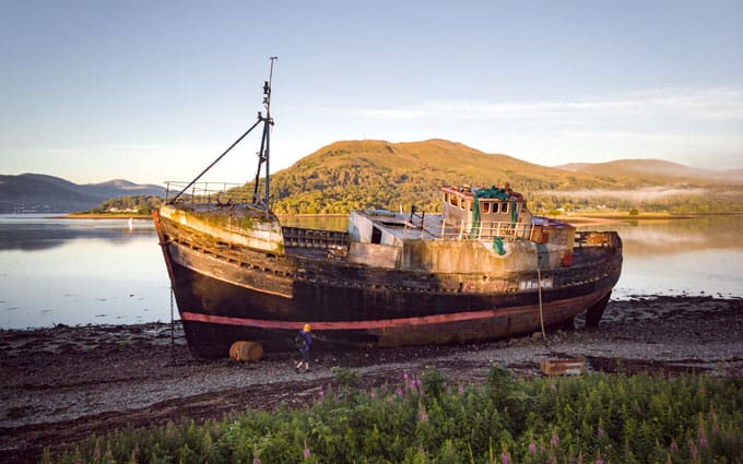Old Boat of Caol (Corpach Shipwreck) abandoned on a beach in Scotland